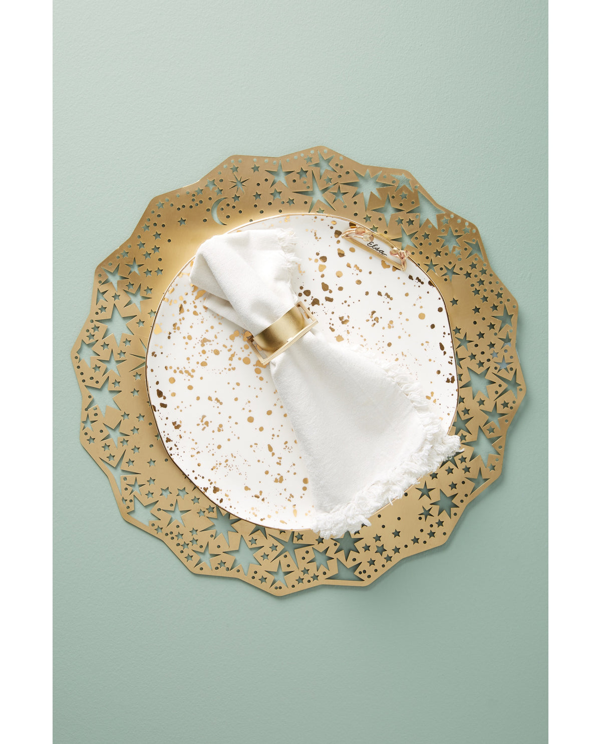 Gold Celestial Placemat Charger under a gold-speckled plate and white napkin - Ariana Ost