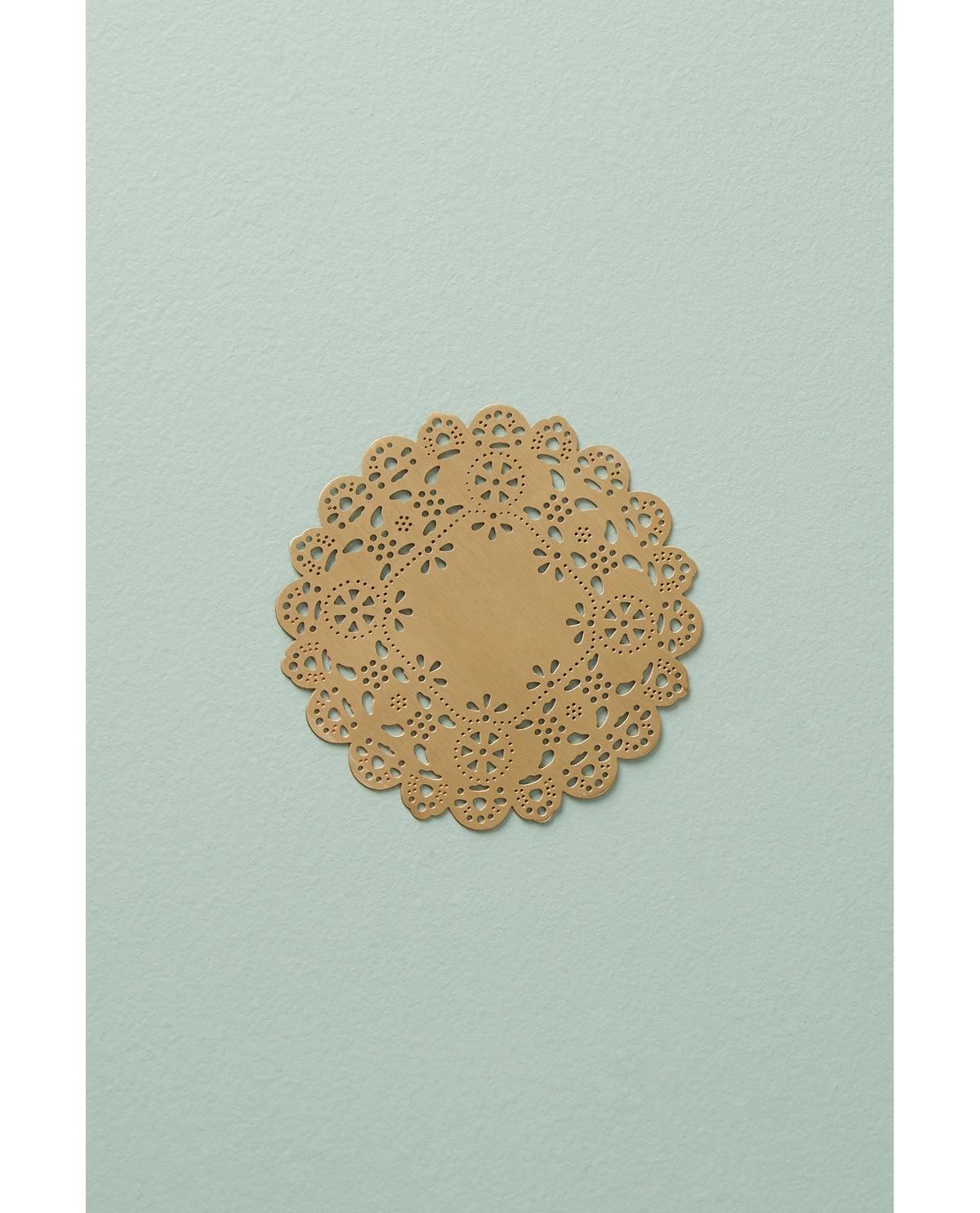 Gold Eyelet Doily Coaster on a sage table - Ariana Ost