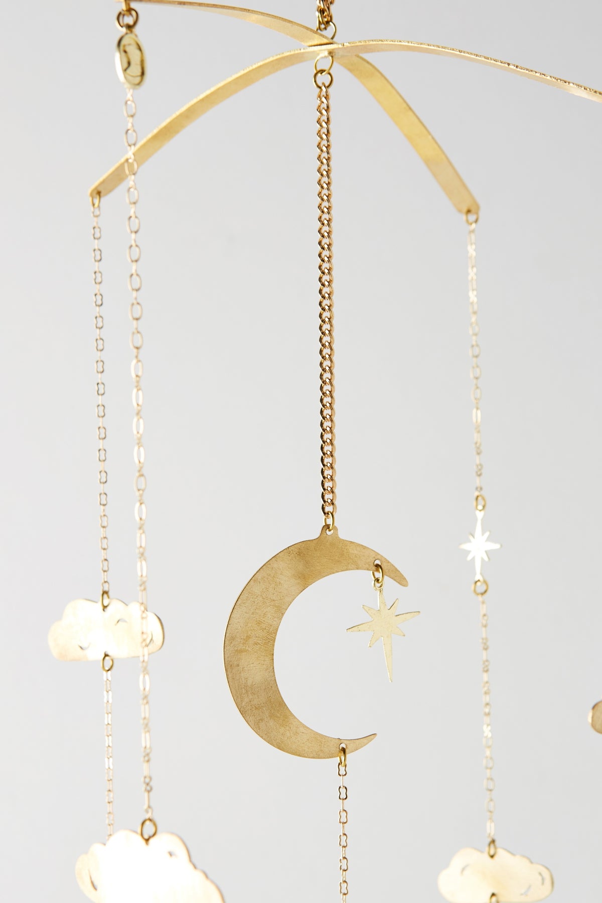 Close-up of the brass crescent moon, star and clouds on the Counting Baby Sheep Mobile - Ariana Ost
