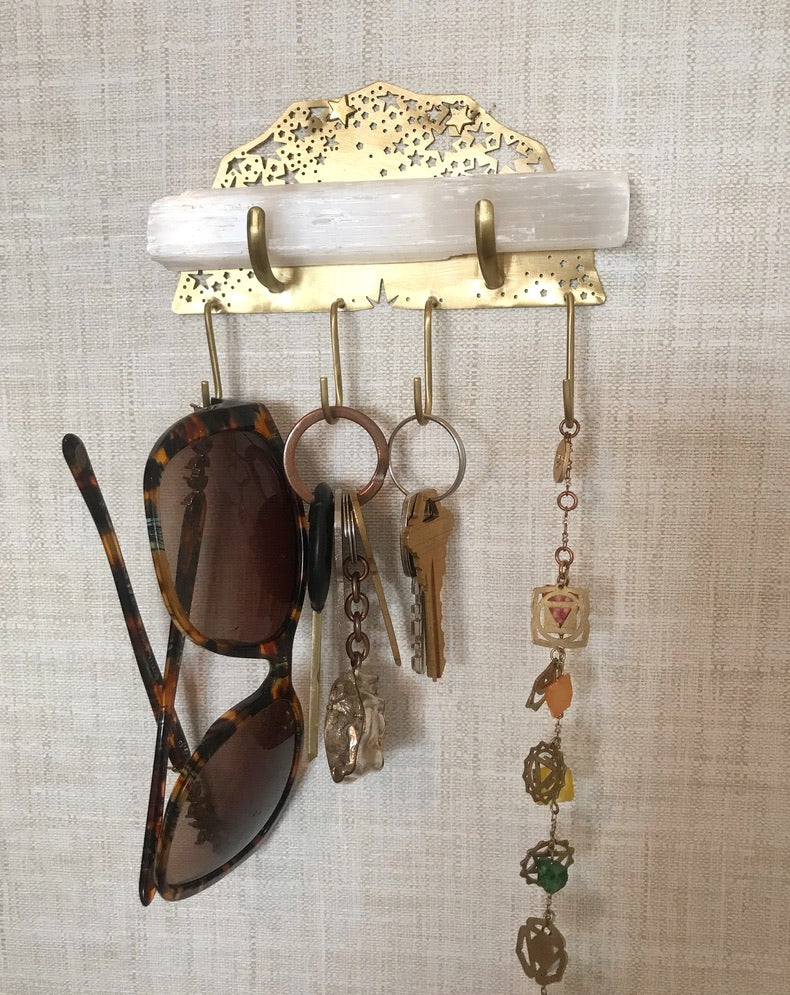 Selenite Wall Hook by the front door holding keys, sunglasses and a charm necklace - Ariana Ost